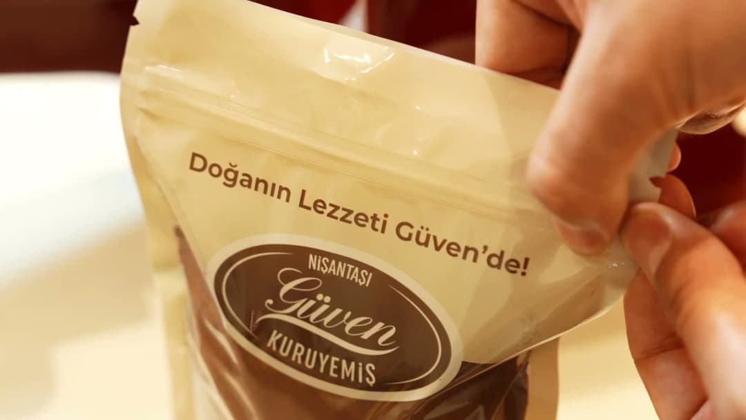 Doğanın Lezzeti Güven'de yazılı kilitli Güven Kuruyemiş paketi açılıyor